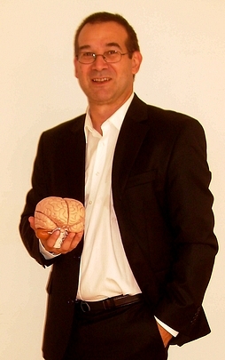 Paul Daniel mit dem Modell eines Gehirns in der Hand